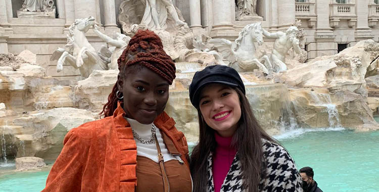 Two students pose outside the Trevi fountain in Rome, Italy. 