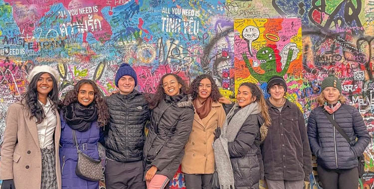 Group of students in front of a colorfully painted wall in Barcelona, Spain. 