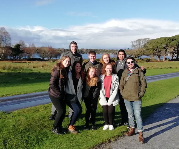 Students pose in front of a castle tower in Ireland.